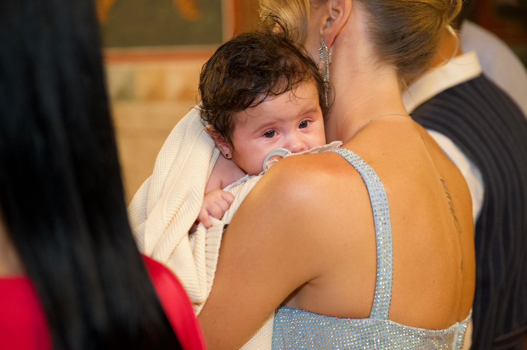 A woman holds a baby wrapped in a blanket.